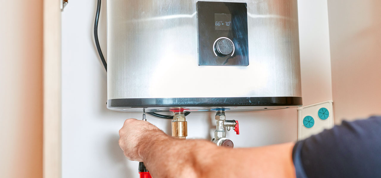 Taps plumber installing a tankless water heater in Houston TX home with wall mounted unit and connected plumbing and gas lines
